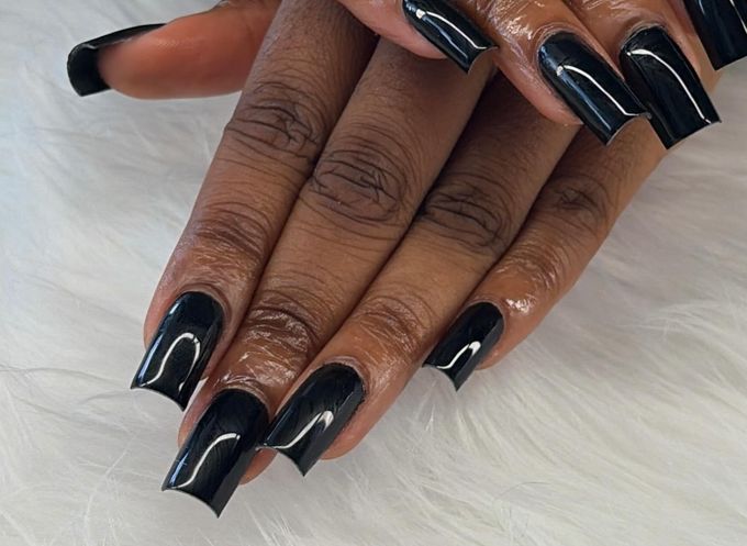 Long square nails in one glossy black on every nail, hands stacked over white fur.