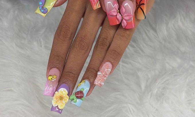 Long duck nails, each one different: a raised purple tentacle on lime, raised pink flowers on a coral fade, a painted palm tree on a sunset fade, a raised yellow flower on lilac, a small raised turtle on baby blue, gold shell and starfish charms and pearls, over white fur.